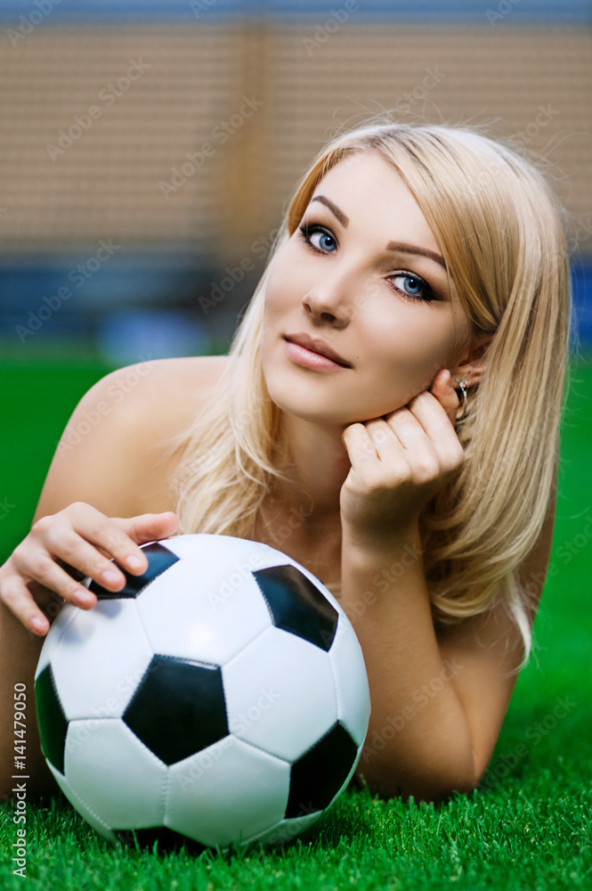 Sexy football (soccer) fan. Young blonde with ball posing on field foto de  Stock | Adobe Stock