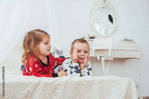 Child in soft warm pajama playing in bed photo