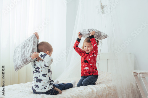 Child in soft warm pajama playing in bed photo