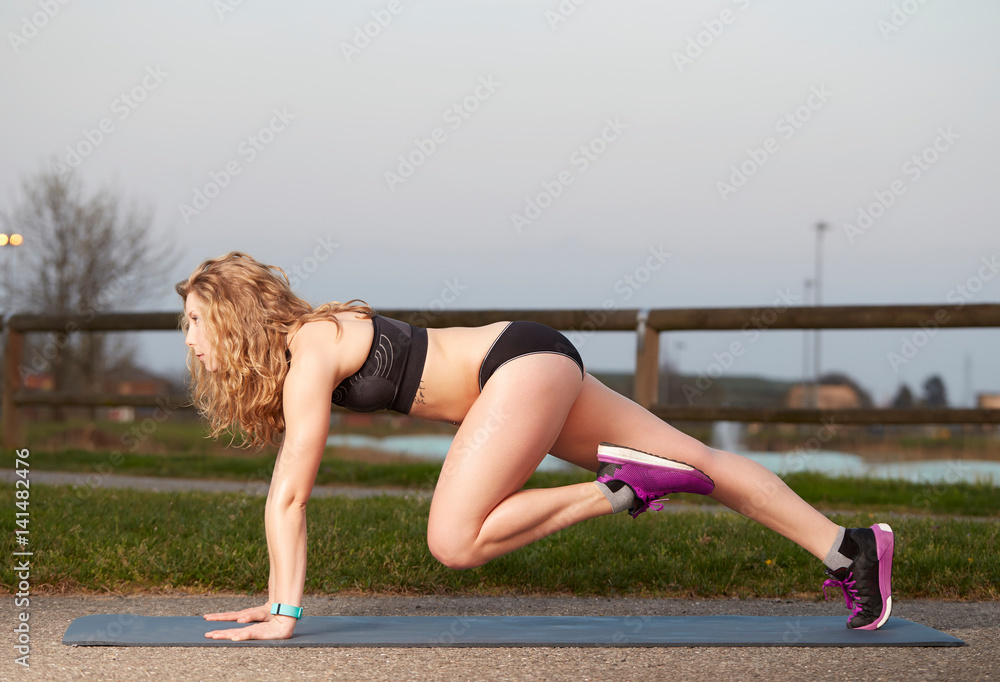 Portrait of a fitness woman sitting training outdoor