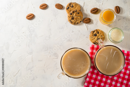Healthy breakfast. Light background with red napkin. Coffee  soy milk  peach juice and cookies with chocolate chips.