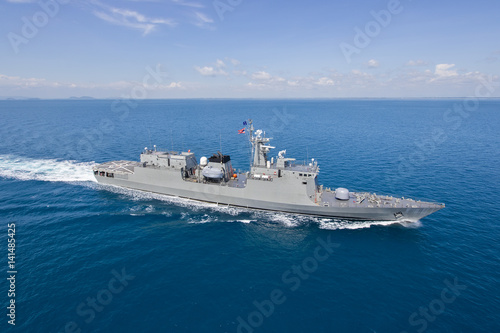 Grey modern warship helicopter view