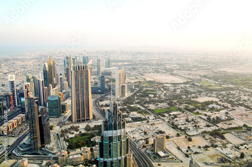 Fototapeta Naklejka Na Ścianę i Meble -  Aerial view of downtown Dubai with buildings skyscrapers and a dusty skyline at sunrise.