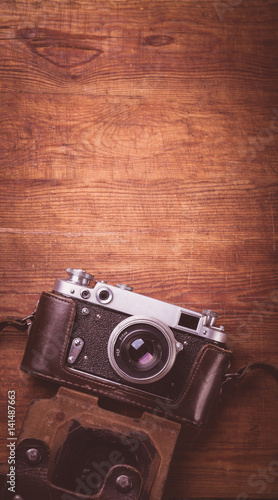 Retro camera on wood table background vintage color tone