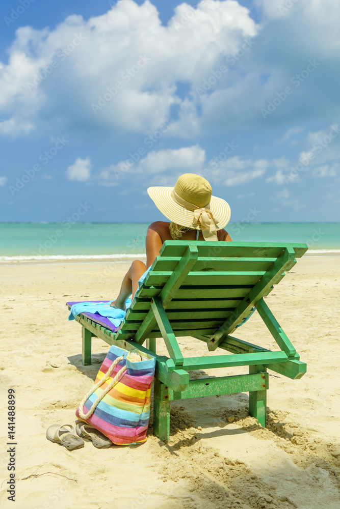 Woman on a deck chair at the beach Woman on a deck chair at the beach