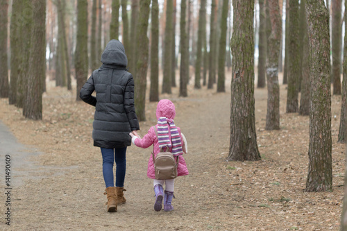 Mom and daughter are walking around the park in the hand