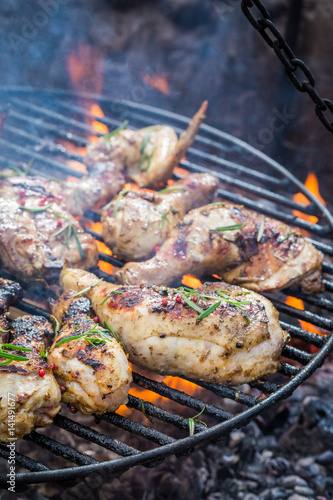 Fresh chicken on grill with rosemary and spices