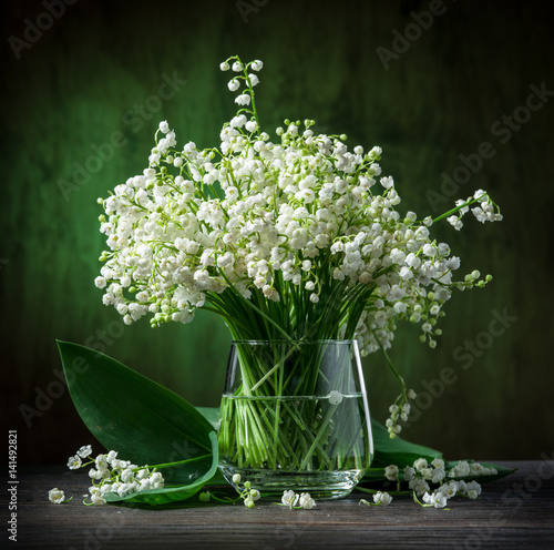 Fotografie Lily of the valley bouquet on the wooden table.