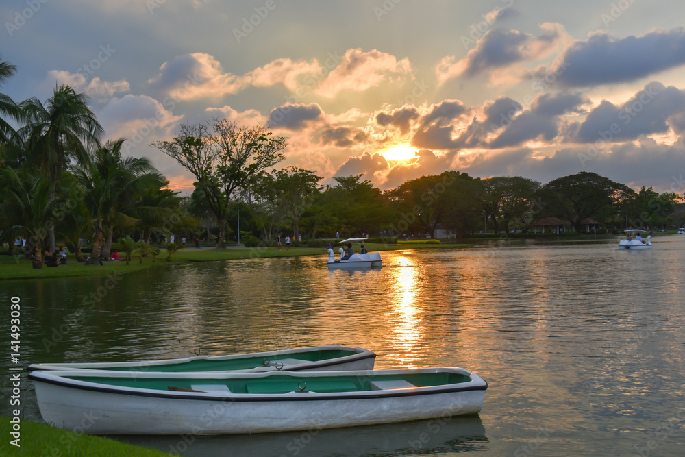 Obraz premium Evening Sun Light And Row Boat in Lake Park Thailand