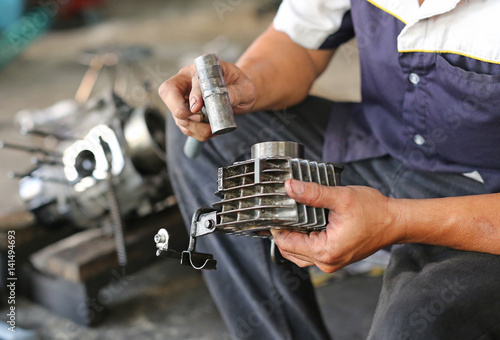 mechanic fixing motocycle engine