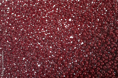 Crimson-red glass beads background - closeup beads texture © leyag