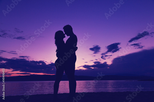 Couple enjoying on the beach in sunset / sunrise time. © astrosystem
