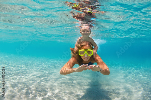 Happy active family - mother, baby son snorkel and dive together underwater in sea pool. Healthy people lifestyle, water sport outdoor adventure, swimming lesson on summer beach vacation with child