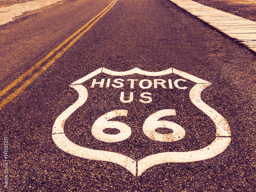 Historic US Route 66 highway sign on asphalt in Oatman, Arizona, United States. The picture was made during a motorcycle road trip through the south western states of USA. photo