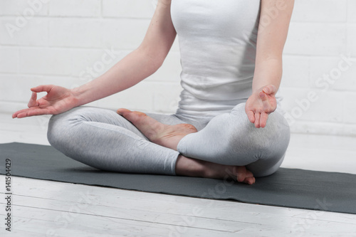 Fit woman practicing yoga meditation indoors