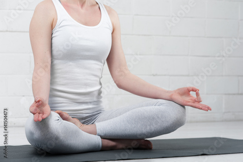 Young woman sitting in yoga meditation pose