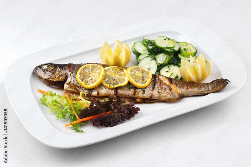 Grilled fish and green salad in a white plate Grilled fish and green salad in a white plate