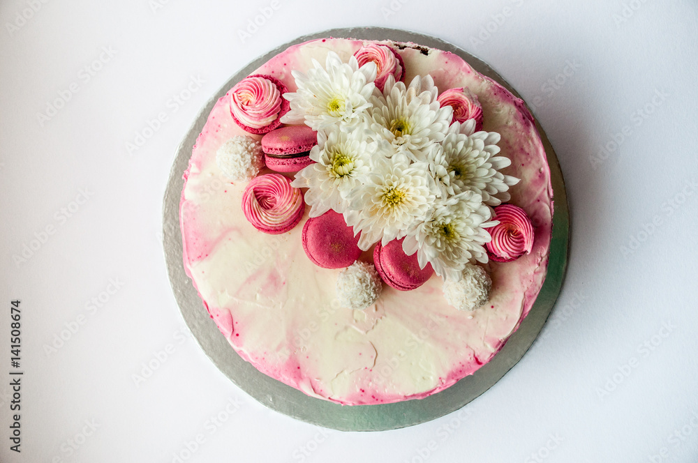 Wedding cake with white spring flowers and macaroon on top. Delicious pink cake isolated on white background. Wedding cake with white spring flowers and macaroon on top. Delicious pink cake isolated on white background.