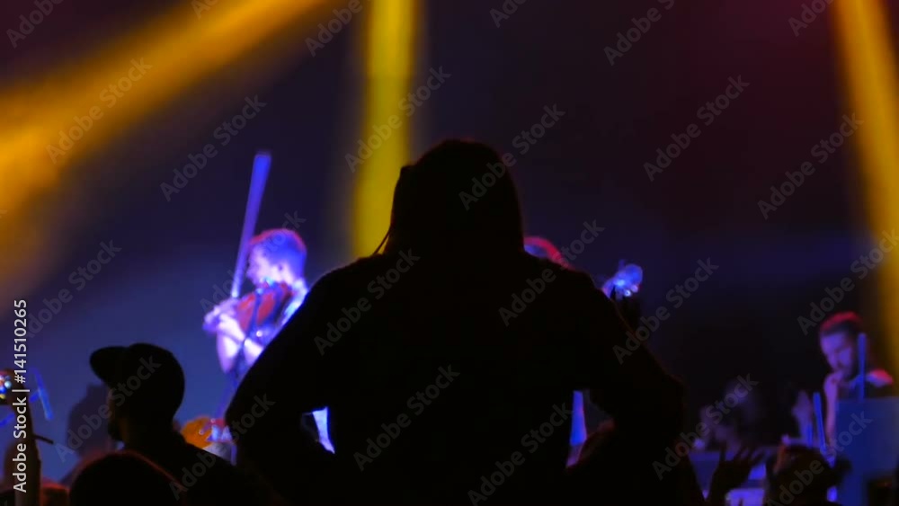 A young girl sits on someone's shoulders and dances in a nightclub A young girl sits on someone's shoulders and dances in a nightclub