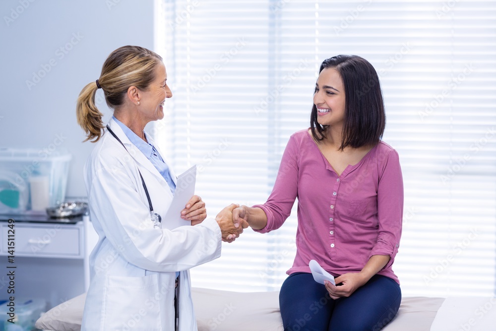 Female doctor shaking hands with patient