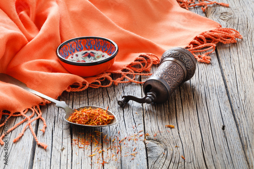 shafran in a spoon on wooden table with silk cloth photo