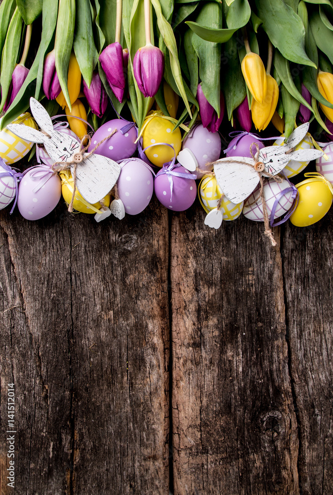 Easter eggs on wooden background. Spring concept on plank. Purple and yellow eggs with nature decoration. Easter eggs on wooden background. Spring concept on plank. Purple and yellow eggs with nature decoration.
