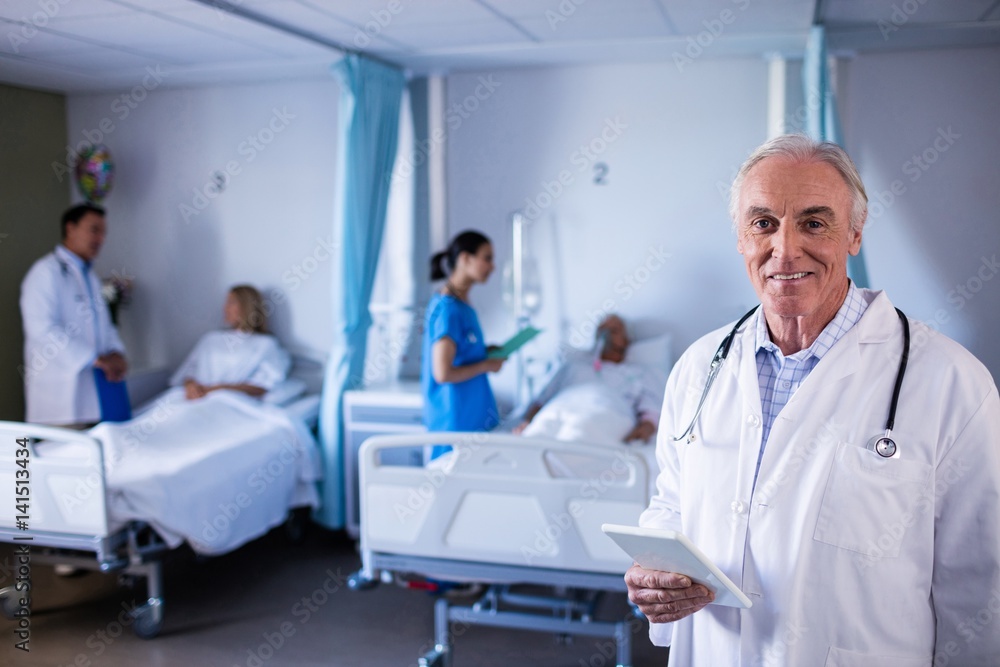 Portrait of male doctor smiling while holding digital tablet Portrait of male doctor smiling while holding digital tablet