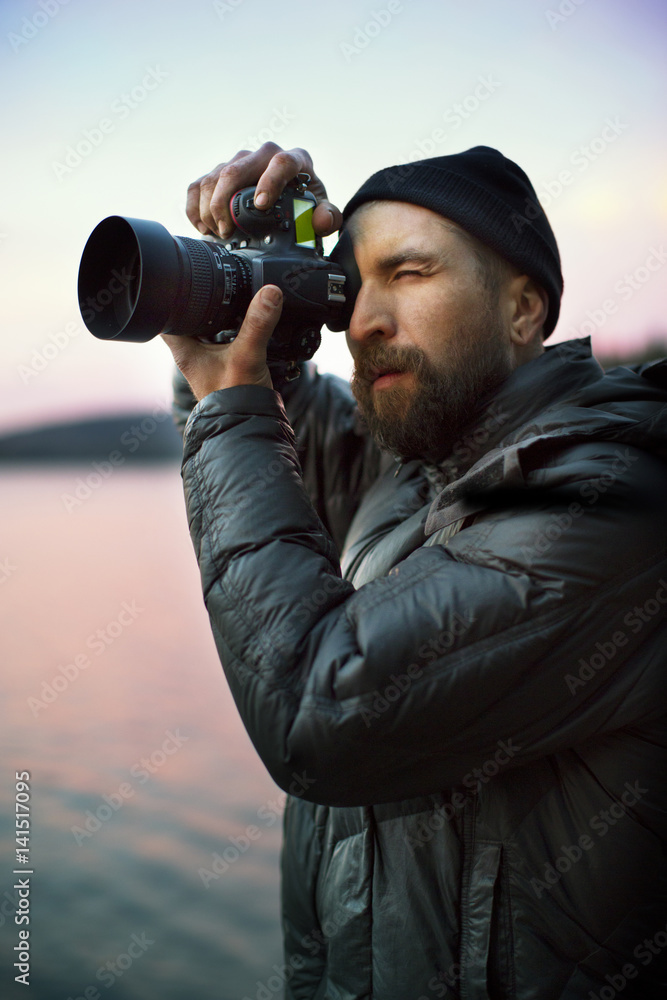 Bearded man taking photograph by lake Bearded man taking photograph by lake
