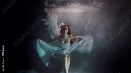 young woman swimming under the water