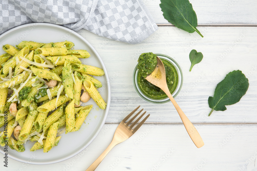 Teller mit Pasta und Pesto aus Radieschengrün auf einem alten weissen Holzuntergrund
