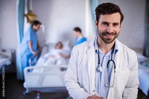 Smiling male doctor standing in hospital