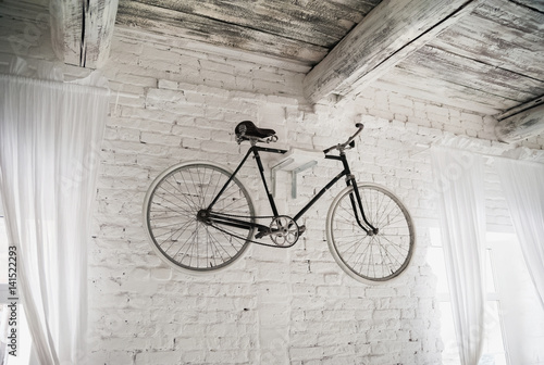 Old white bicycle whist on a white stone wall. Details of the old bicycle.