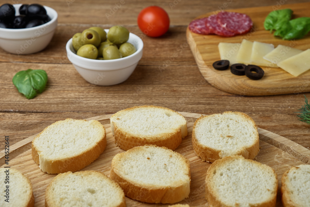 Delicious Crostini with different toppings on wooden background Delicious Crostini with different toppings on wooden background