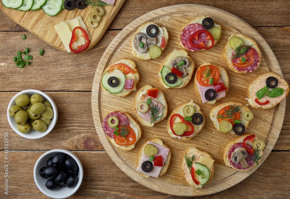 Delicious Crostini with different toppings on wooden background Delicious Crostini with different toppings on wooden background