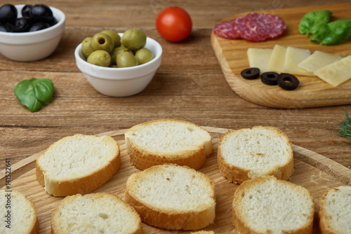 Delicious Crostini with different toppings on wooden background