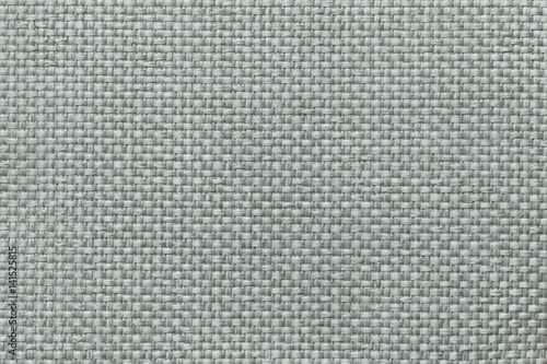 Green background with braided checkered pattern, closeup. Texture of the weaving fabric, macro.