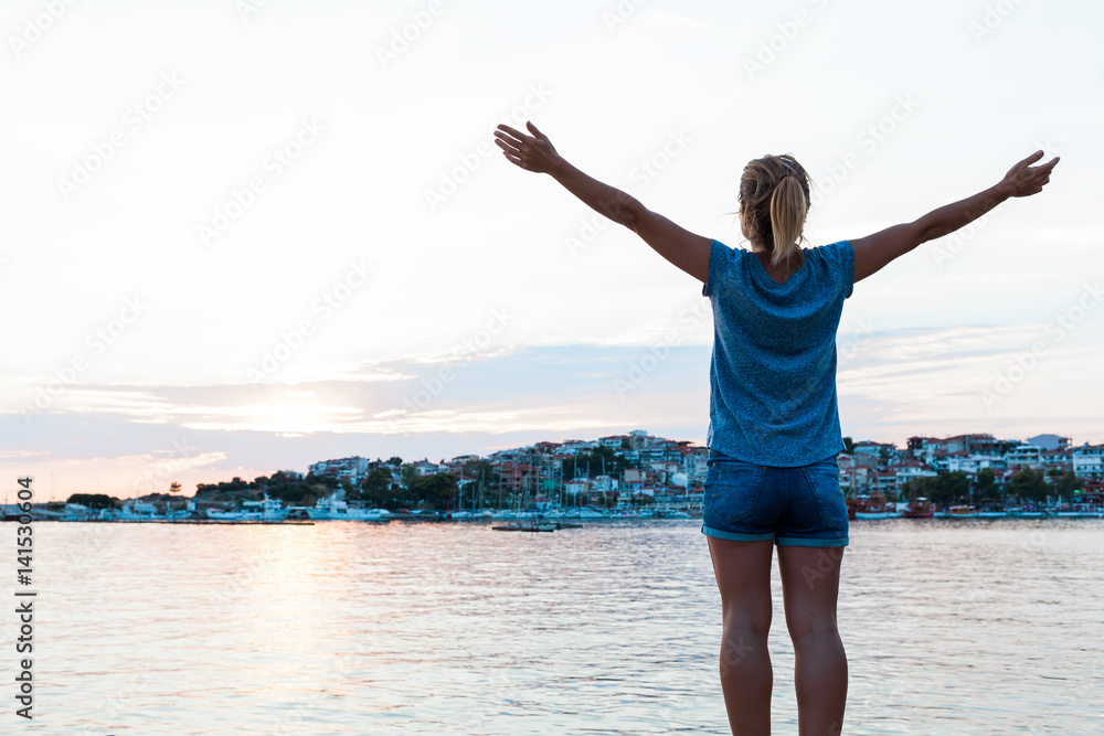 Young woman enjoying sunset in the seaside Young woman enjoying sunset in the seaside