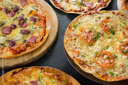 Various pizza arranged on a wooden tray