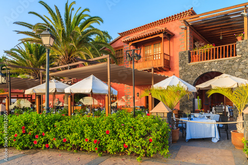 Typical restaurant built in colonial style during sunset time in Costa Adeje holiday town on Tenerife island, Spain