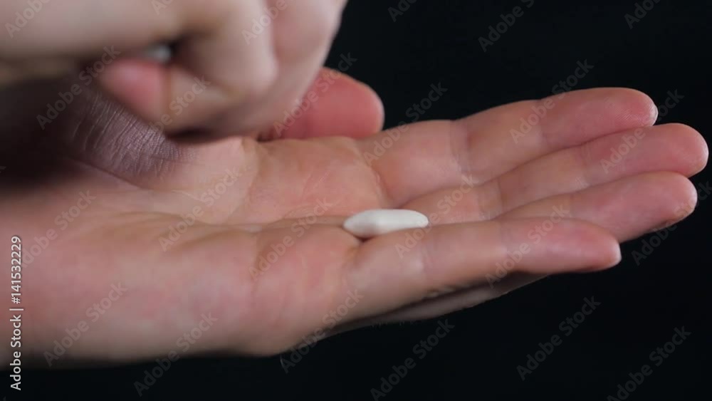 Close up young man holding chewing gums in his hand. Close up young man holding chewing gums in his hand.