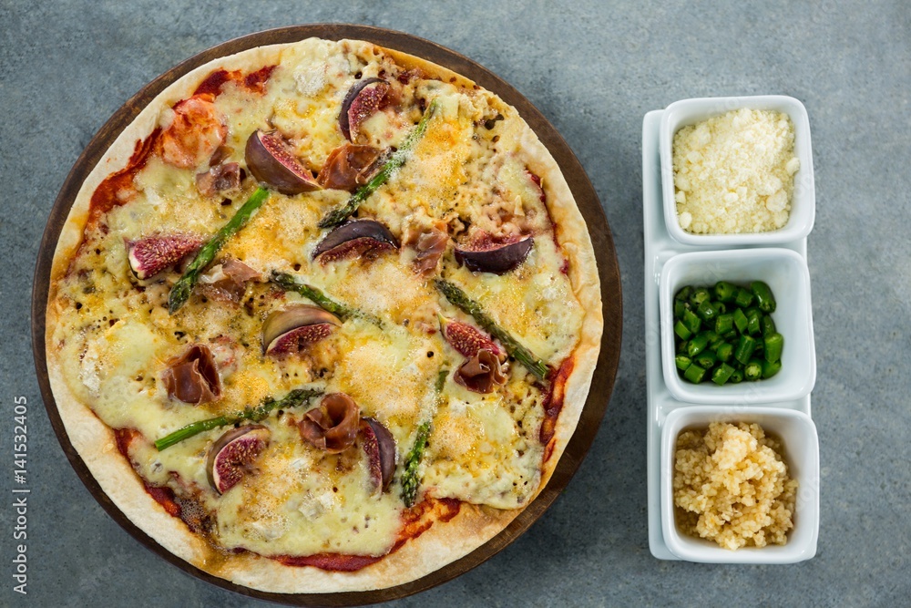 Italian pizza served with ingredients on a pizza tray Italian pizza served with ingredients on a pizza tray