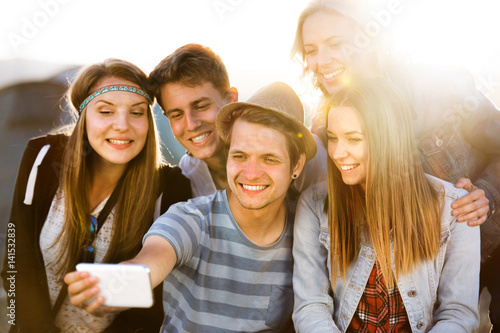 Teenagers at summer music festival  taking selfie with smartphon