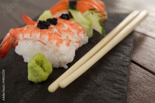 Nigiri sushi served in black stone slate on wood