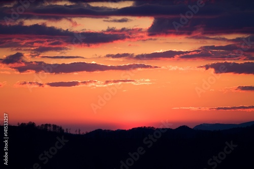 Sunrise in Slovakia. Orange sun sky over dark mountains. Romantic atmosphere. Fog hills at sunset.
