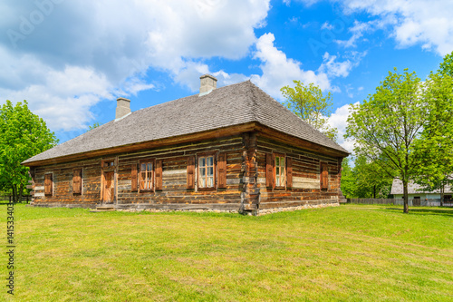 Old traditional wooden house in Tokarnia village on sunny spring day, Poland