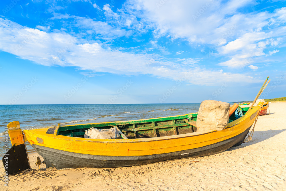 Colorful fishing boat on sandy Debki beach during sunny summer day, Baltic Sea, Poland
