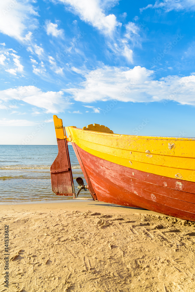 Colorful fishing boat on sandy Debki beach during sunny summer day, Baltic Sea, Poland Colorful fishing boat on sandy Debki beach during sunny summer day, Baltic Sea, Poland