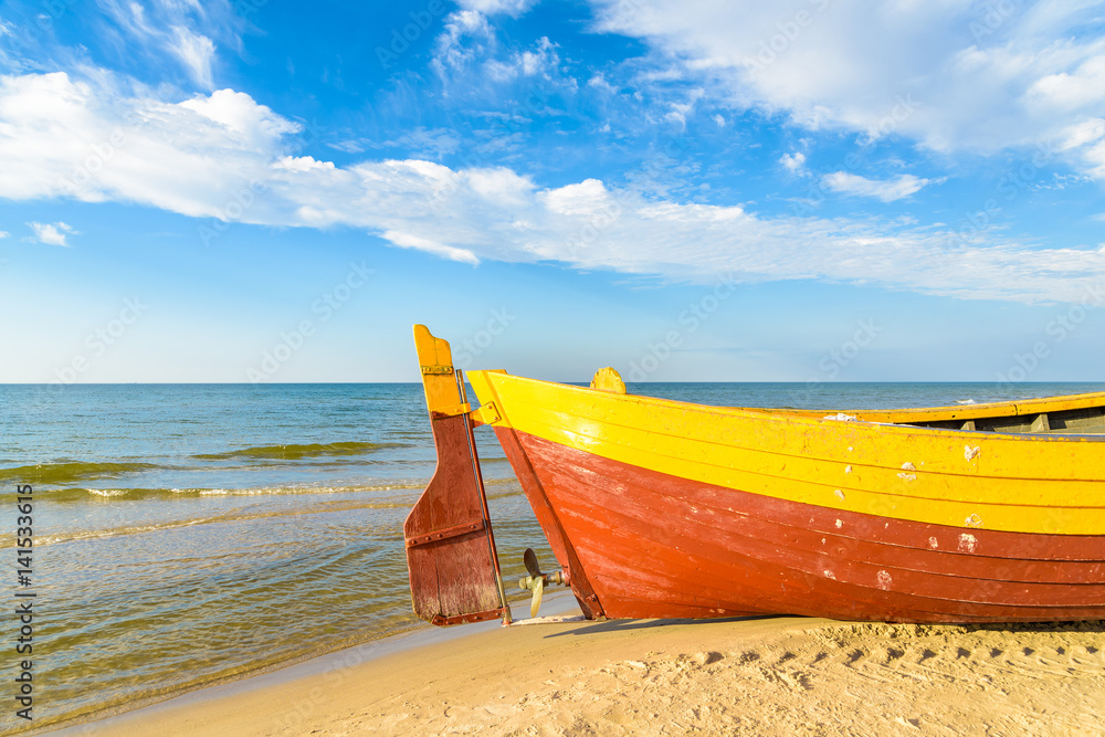 Colorful fishing boat on sandy Debki beach during sunny summer day, Baltic Sea, Poland Colorful fishing boat on sandy Debki beach during sunny summer day, Baltic Sea, Poland