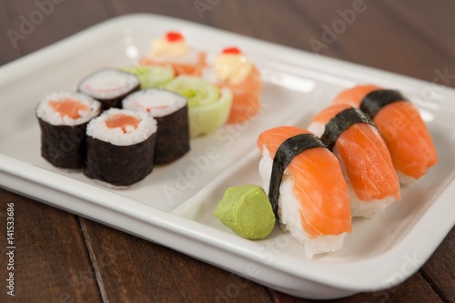 Uramaki and nigiri sushi served in white plate