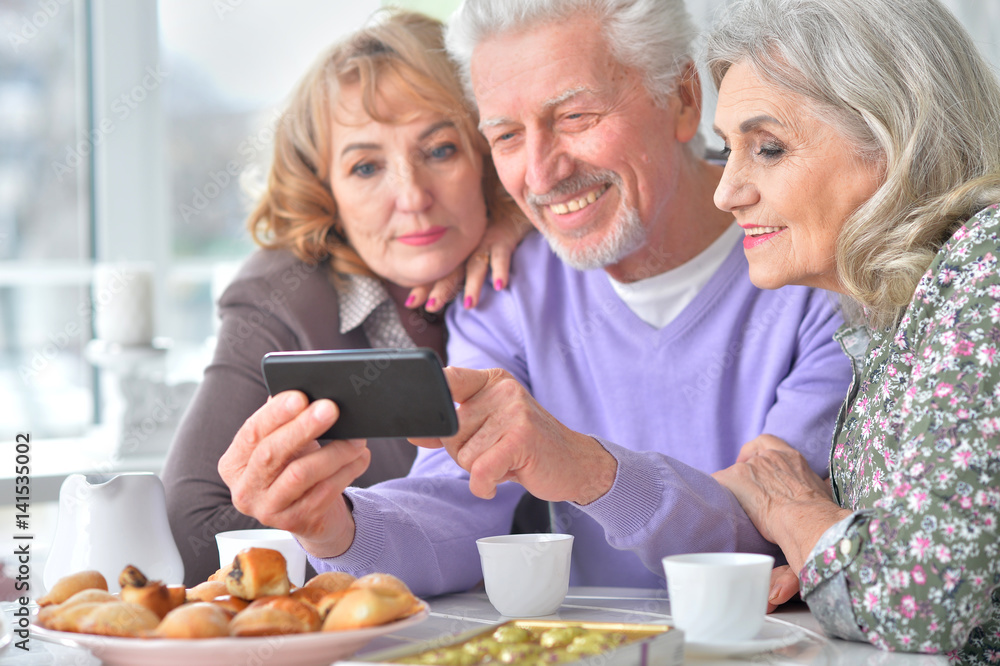 Elderly people having breakfast and using mobile phone Elderly people having breakfast and using mobile phone